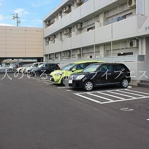 敷地内駐車場 建物の向こうの道はレインボーロード